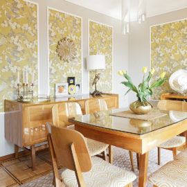 GR&J Baker Heron wallpaper in yellow and grey dining room with Mid-century modern dining set and brass accents