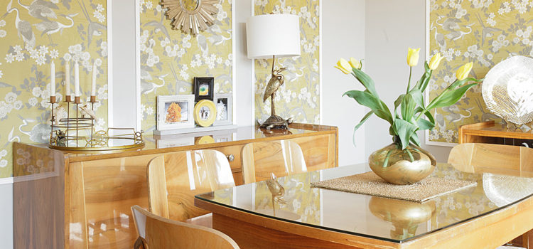 GR&J Baker Heron wallpaper in yellow and grey dining room with Mid-century modern dining set and brass accents