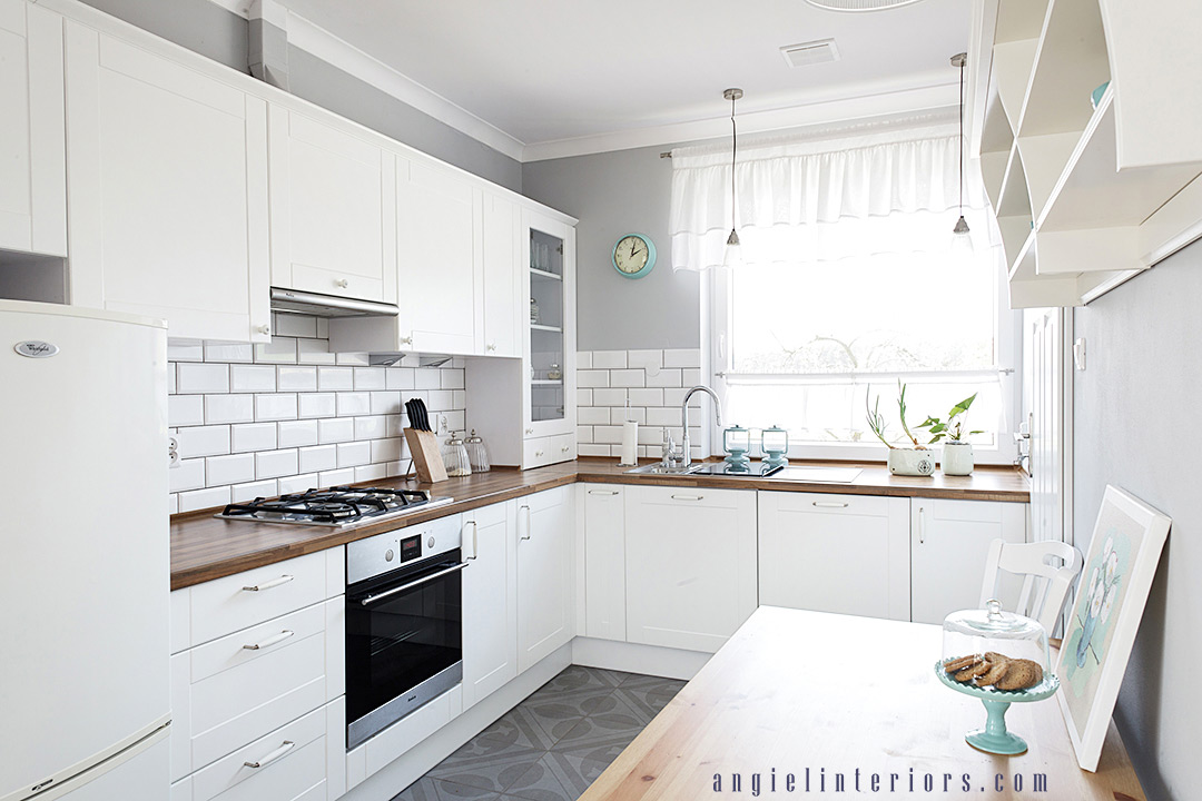 small kitchen with white cabinets, butchers block countertop, grey walls and patterned floor tiles, subway tile backsplash and turquoise accents