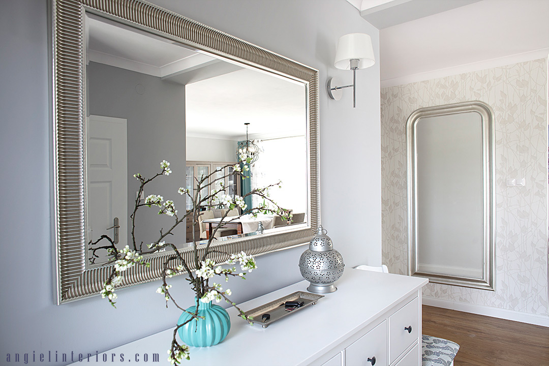 bright grey and white entry with Ikea Hemnes dresser, silver mirrors, sconces and botanical wallpaper