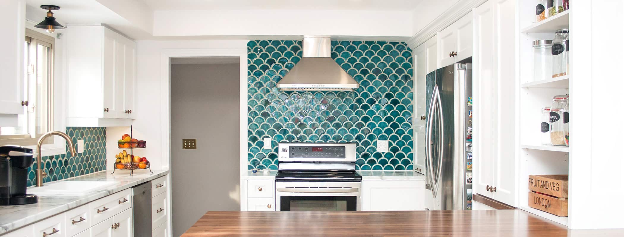 Contemporary white kitchen with fishscale teal tile backsplash