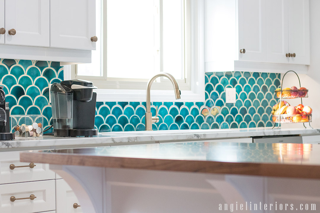 Shaker style cabinets with champagne gold hardware and teal ceramic tiles backsplash