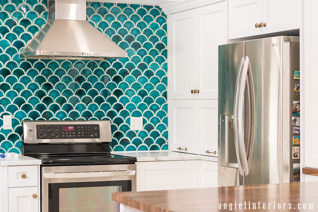 Shaker style cabinets with champagne gold hardware and statement teal fishscale tiles bascsplash