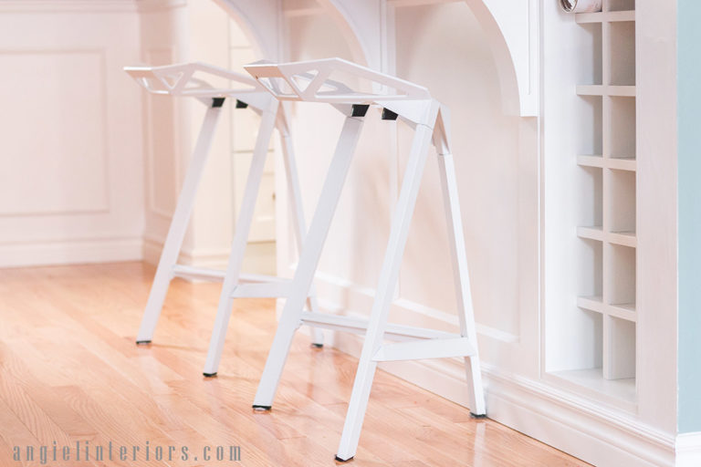 Modern stools at peninsula and wine rack in white kitchen and dining room