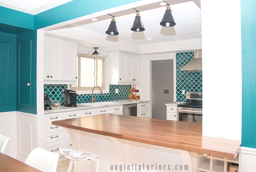 Fishscale teal tiles, white cabinets and champagne gold accents in modern kitchen