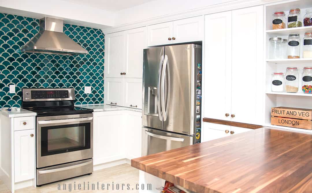 Fishscale teal tiles, white cabinets and champagne gold accents in modern kitchen