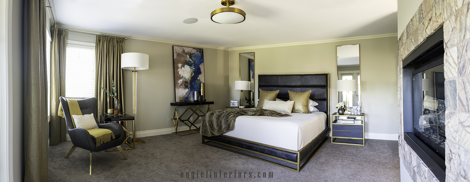 bedroom with modern bed, gold mirrors, geometric gold and black console table and oversized abstract painting