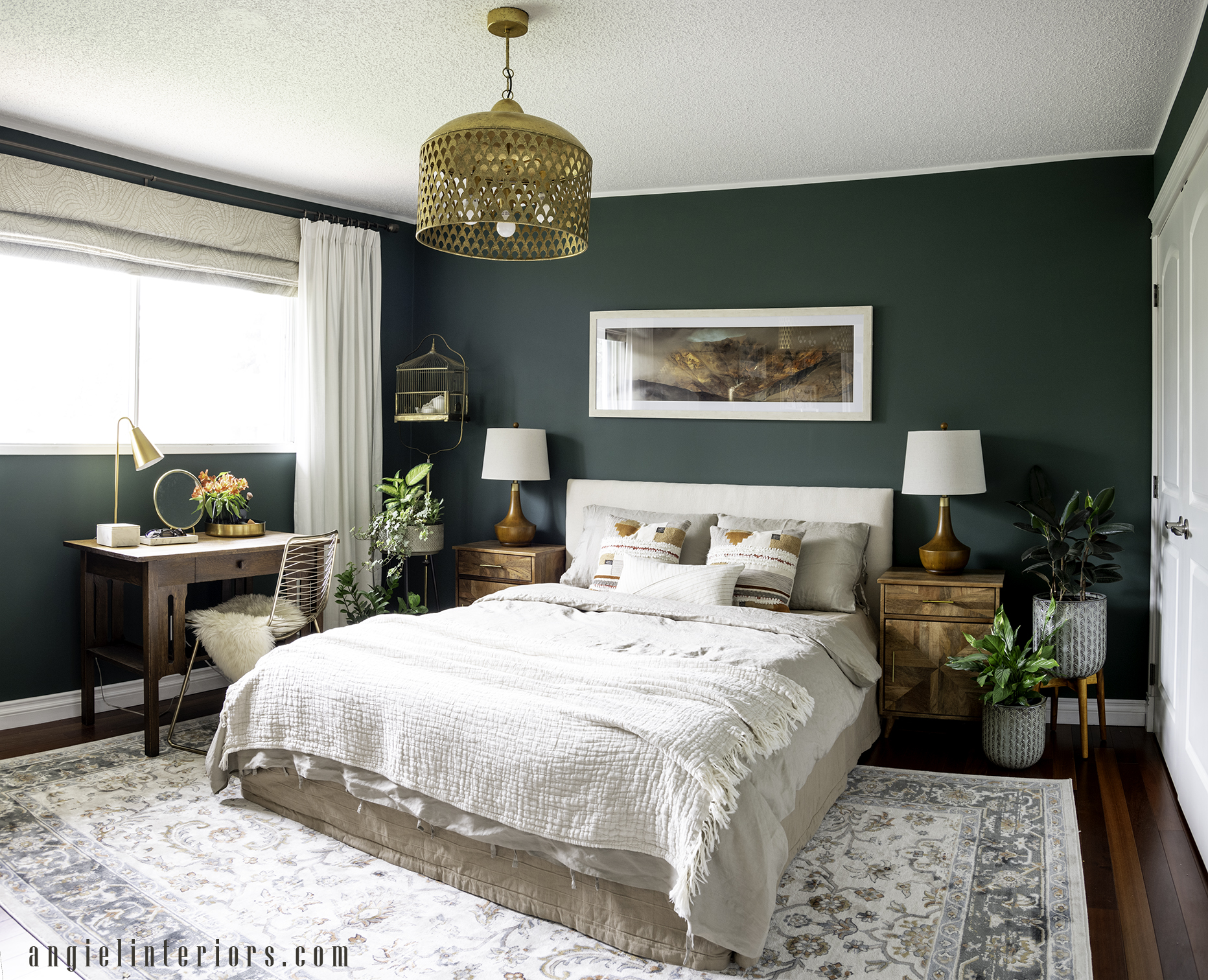 dark green bedroom with wooden nightstands and antique desk and brass accents