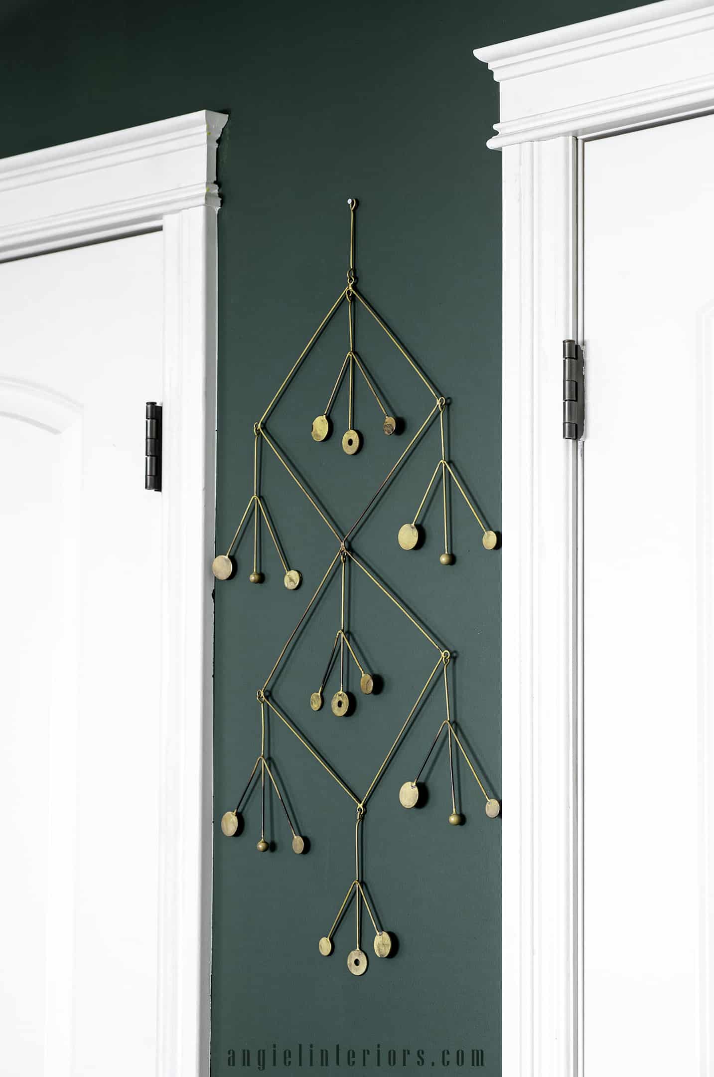 golden mobile decoration on a dark green wall