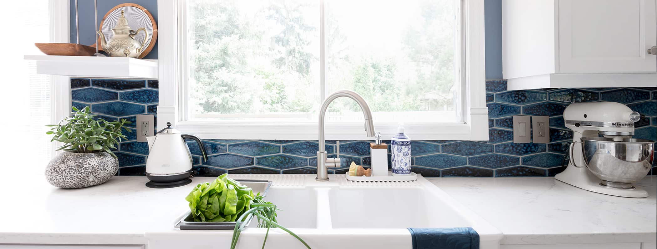 kitchen with apron sink blue backsplash tiles and quartz countertop