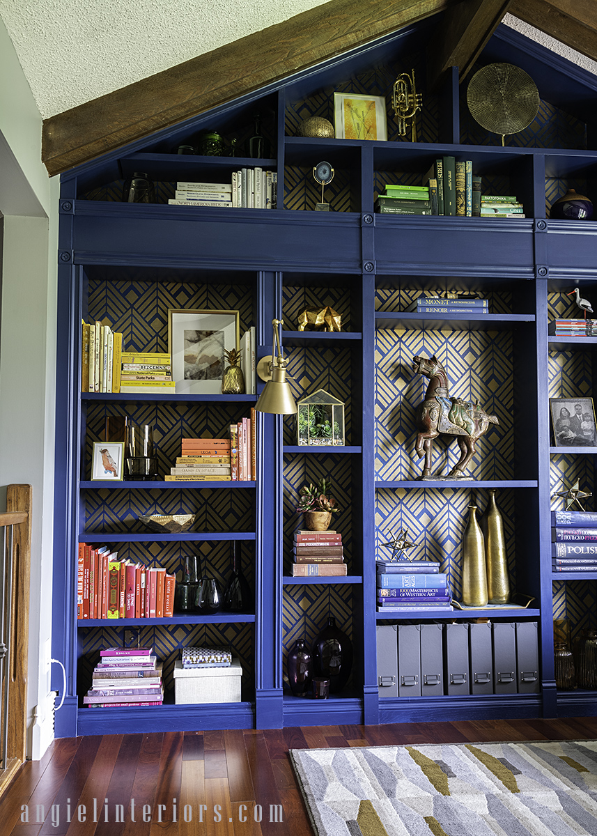 Home library with built in IKEA hacked bookcase under vaulted ceiling